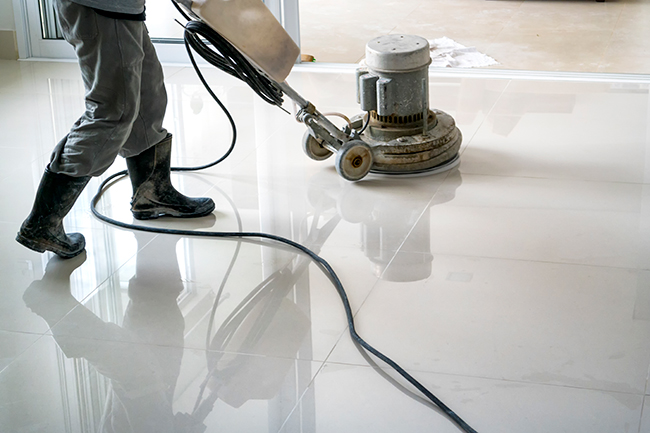 man cleaning floor with machine